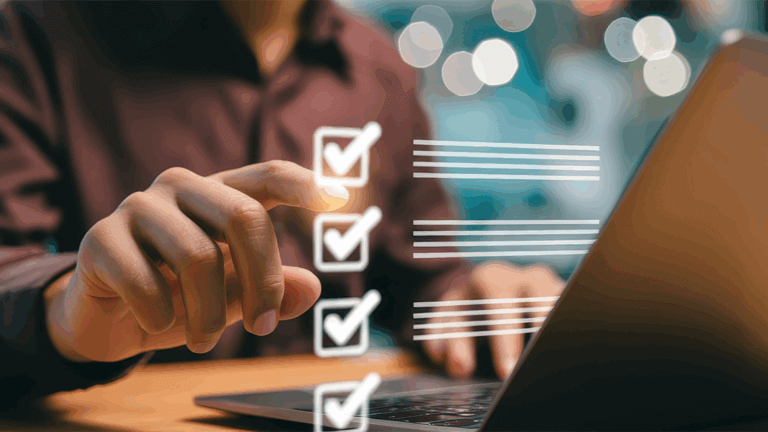 A person at a desk with a laptop checking off virtual boxes in the air.