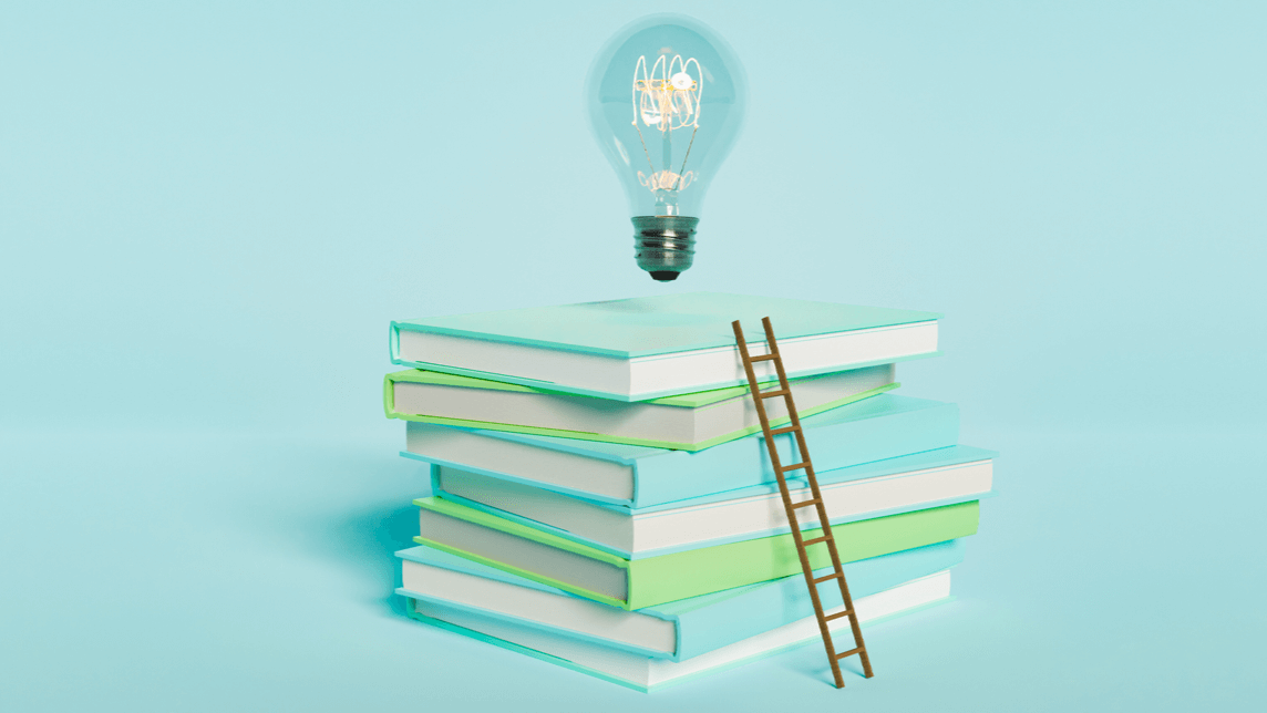 Stack of books with a wooden ladder leaning against them and a glowing lightbulb above, symbolizing learning and ideas.