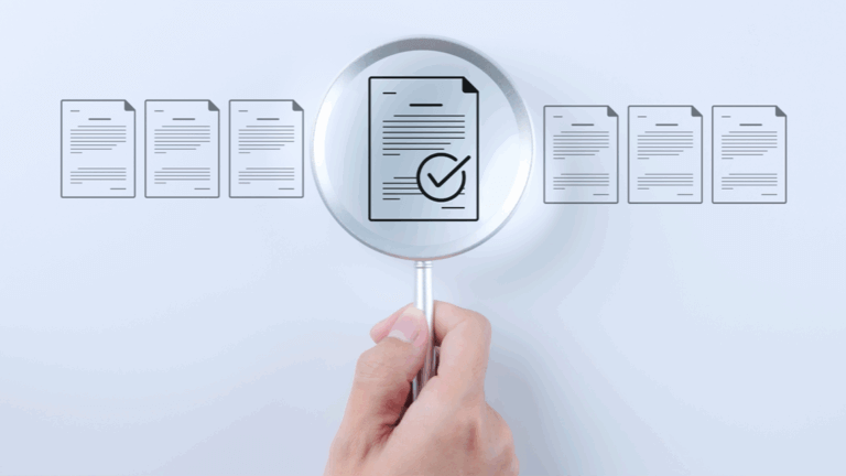 Hand holding magnifying glass examining document with checkmark among other documents.