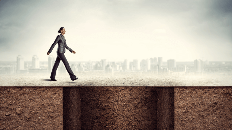 usiness professional walking confidently across a gap between cliffs toward a city skyline.