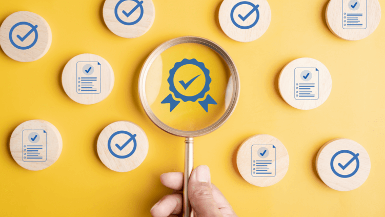 Magnifying glass focusing on quality assurance badge surrounded by checkmark and checklist icons.
